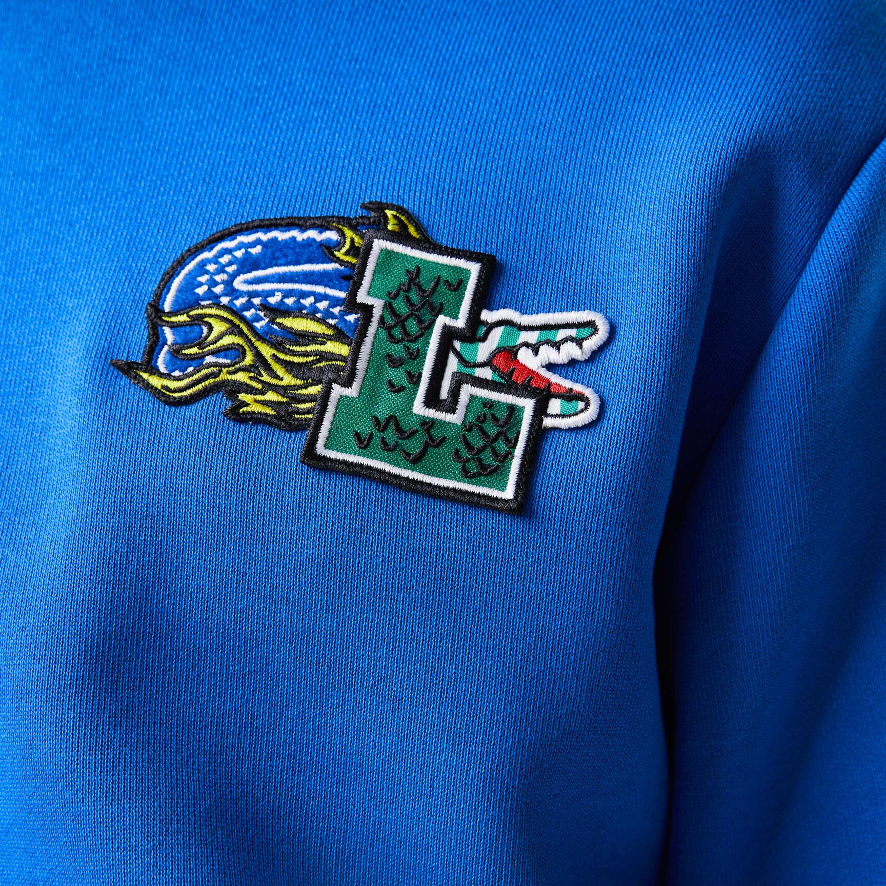 سويت شيرت بغطاء رأس لاكوست بنقشة قصص مصورة من تشكيلة موسم الأعياد للرجال سويت شيرت بغطاء رأس لاكوست بنقشة قصص مصورة من تشكيلة موسم الأعياد للرجال