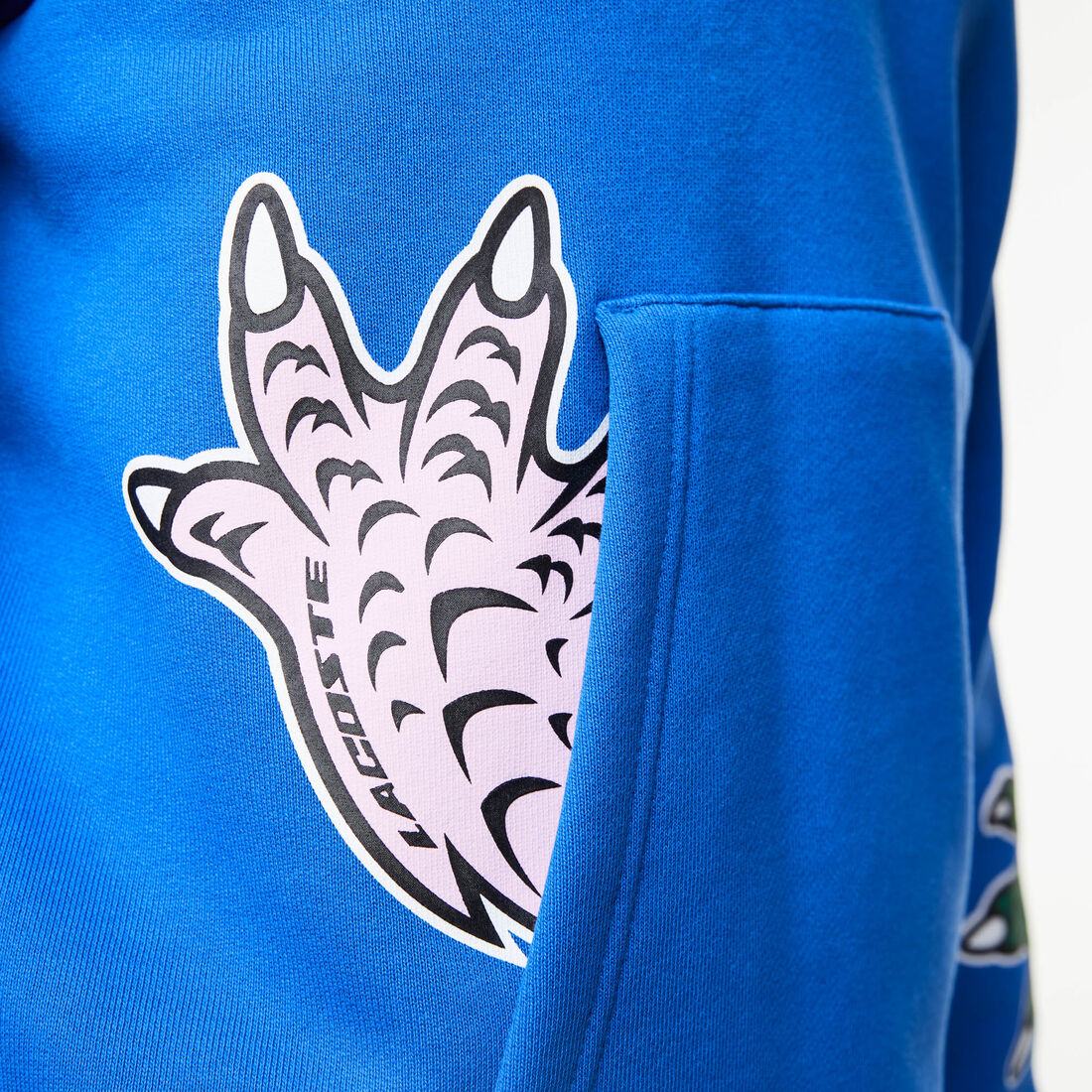 سويت شيرت بغطاء رأس لاكوست بنقشة قصص مصورة من تشكيلة موسم الأعياد للرجال سويت شيرت بغطاء رأس لاكوست بنقشة قصص مصورة من تشكيلة موسم الأعياد للرجال